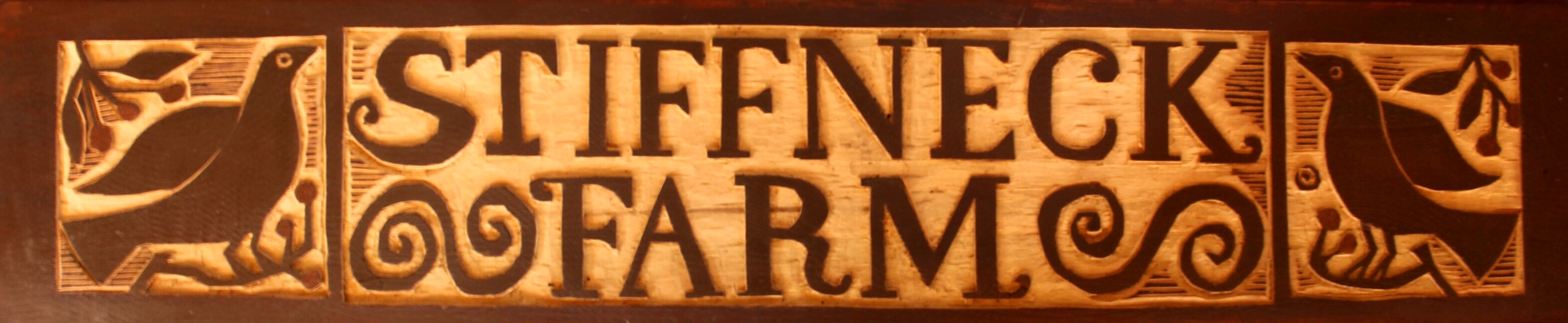 Photo of a StiffNeck Farm wood carved sign by artist Doug Frati of Stiff Neck Farm.